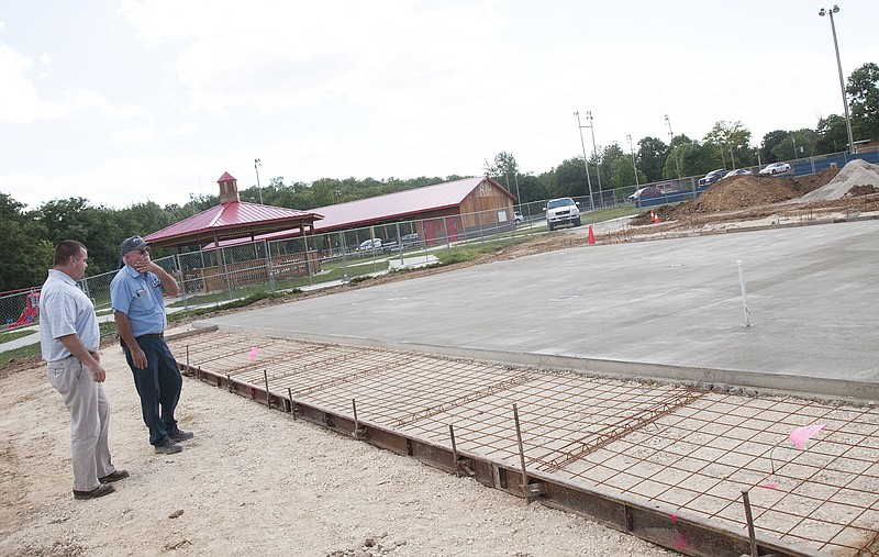 Fulton Parks and Recreation Director Clay Caswell and a city employee discuss the splash pad - an upcoming feature to Memorial Park. A subcontractor poured concrete Tuesday for the attraction's main area, and Caswell said more concrete will be poured this week for sidewalks and a shaded portion of the splash pad.