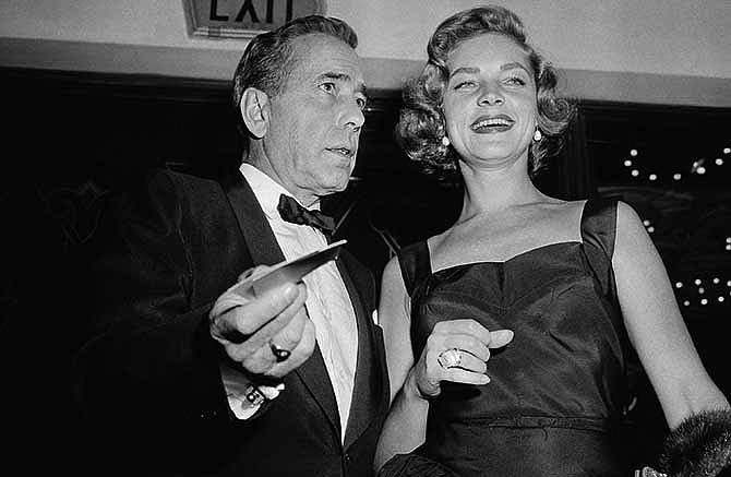 This Oct. 12, 1955 file photo shows actors Humphrey Bogart, left, and his wife, Lauren Bacall at the premiere of "The Desperate Hours," in Los Angeles. Bacall, the sultry-voiced actress and Humphrey Bogart's partner off and on the screen, died Tuesday, Aug. 12, 2014 in New York. She was 89. 