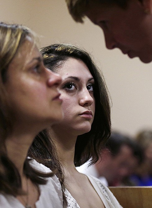 Abigail Hernandez, center, listens to her mother Zenya Hernandez, left, talk with New Hampshire senior assistant Attorney General Jane Young in Conway District Court in Conway, New Hampshire, prior to the arraignment of Nathaniel Kibby, 34. 