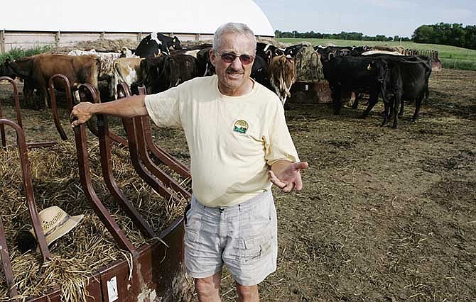 This May 31, 2006 file photo shows Dave Minar, who with his wife and family own Cedar Summit Farm near New Prague, Minn. The small organic dairy has prevailed in its legal effort to force a buyout by a utility building high-voltage power lines along the property.
