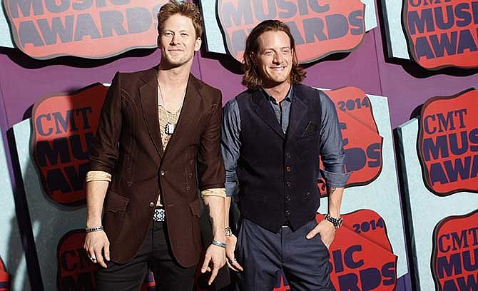  This June 4, 2014 file photo shows Brian Kelley, left, and Tyler Hubbard of the musical group Florida Georgia Line arrive at the CMT Music Awards at Bridgestone Arena on in Nashville, Tenn. The duo will release their latest album, "Anything Goes," out Oct. 14. 