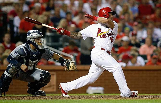 St. Louis Cardinals' Kolten Wong follows through on a RBI single to score Jon Jay during the fourth inning of a baseball game against the San Diego Padres Friday, Aug. 15, 2014, in St. Louis.