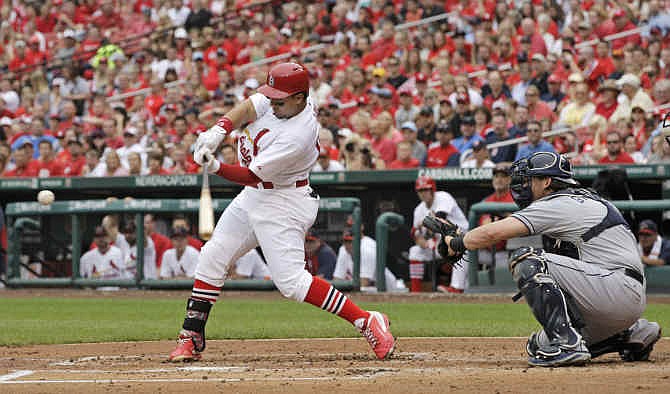 St. Louis Cardinals' Jon Jay (19) connects for a two-RBI single as San Diego Padres catcher Yasmani Grandal watches in the first inning of a baseball game, Sunday, Aug. 17, 2014, in St. Louis. 