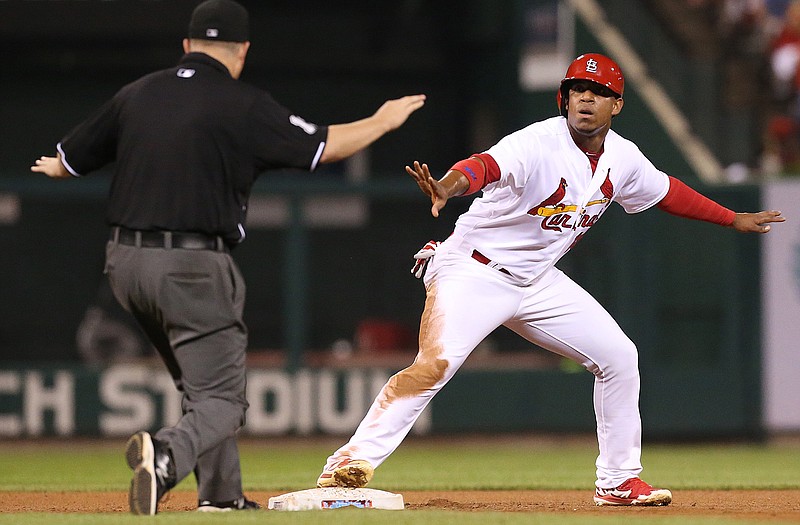 Second base umpire Todd Tichenor calls Oscar Taveras of the Cardinals safe after he stole second base during Monday night's game with the Reds at Busch Stadium. The call was overturned after a replay challenge and ended the fourth inning.