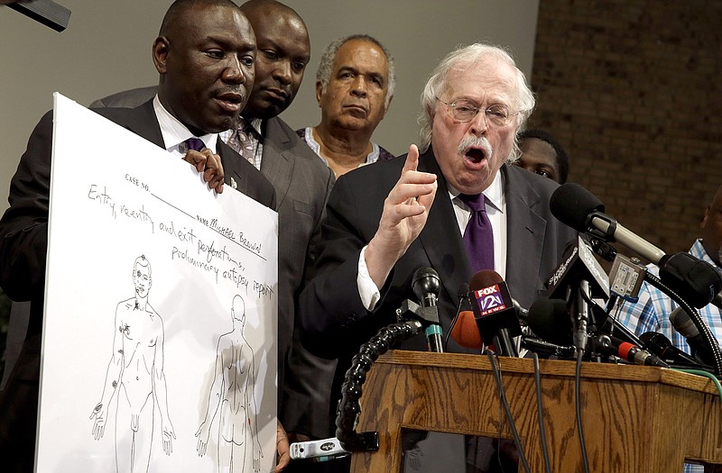 Dr. Michael Baden, right, speaks as Brown family attorney Benjamin Crump, left, holds a diagram produced during a second autopsy done on 18-year-old Michael Brown. The independent autopsy shows Brown was shot at least six times.