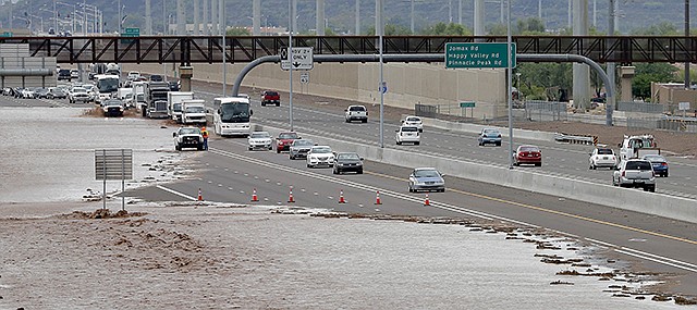 Flash flood waters from the overrun Skunk Creek flood I-10, Tuesday in northwestern Phoenix. Flooding from heavy rain in the Phoenix area has forced authorities to close several major roads, including a portion of Interstate 17 about 25 miles north of the city.