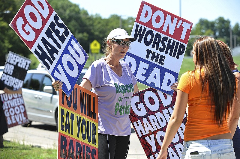 Counter-protestors engage Rachel Hockenbarger, at left, in conversation on Aug. 19, 2014, during a protest staged in Jefferson City by Westboro Baptist Church.
