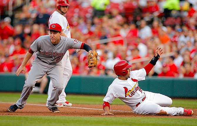 Cincinnati Reds first baseman Todd Frazier, left, looks for the call after tagging out St. Louis Cardinals' Jon Jay on a double play to end the first inning during a baseball game Wednesday, Aug. 20, 2014, in St. Louis. Matt Adams flew out to center to start the double play. 