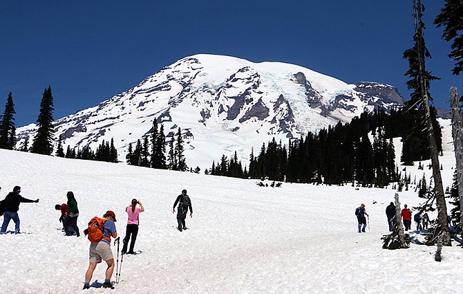 Visitors hike through the snow at the trails that start from Mount Rainier's Paradise Visitor Center. Officials on Wednesday said that the bodies of three climbers have been retrieved from a glacier on the mountain in the same area where six went missing in May. 