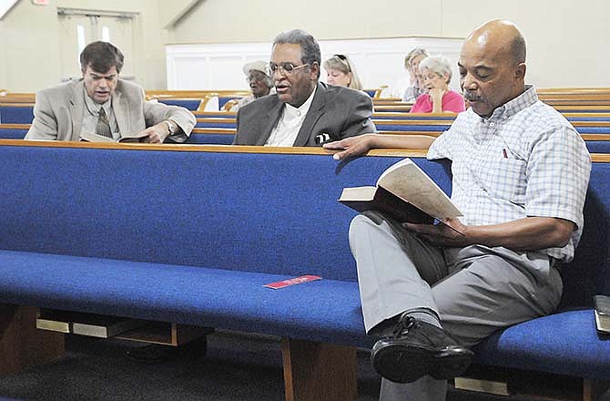 Rev. Cornell Sudduth, right, prays to God asking for peace and to "let it begin with us" during a vigil at Second
Baptist Church on Wednesday. Prayers were for the community of Ferguson in particular and everywhere else there is unrest. He and Rev. James Wheeler, middle, both from Second Baptist Church, and Rev. Rob Erickson from the First Presbyterian Church took turns leading prayer and songs during the vigil.
