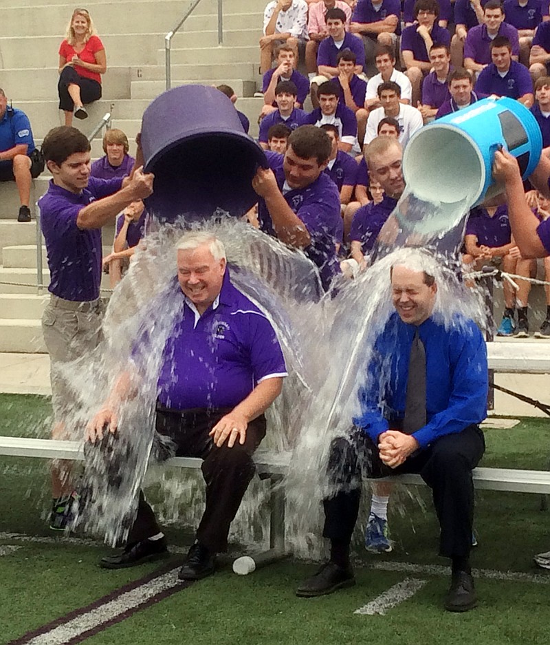 Jim Rigg, right, superintendent of the diocese's 113 schools, and Elder High School Principal Tom Otten take the ice-bucket challenge at Elder High School in Cincinnati. The archdiocese is discouraging its students and staff from donating any money raised as part of the challenge to the ALS Association, saying the group funds a study involving embryonic stem cell research "in direct conflict with Catholic teaching."