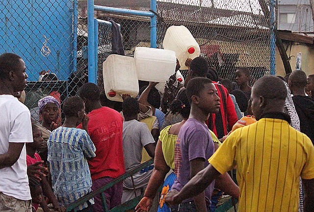 West Point residents try to buy water, rear, in one of the areas were the Ebola virus has claimed lives in Monrovia, Liberia, Thursday. Calm returned Thursday to a slum in the Liberian capital that was sealed off in the government's attempt to halt the spread of Ebola.
