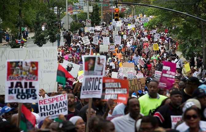 Demonstrators march to protest the death of Eric Garner, Saturday, Aug. 23, 2014, in the Staten Island borough of New York. The city medical examiner ruled that Garner, 43, died as a result of a police chokehold during an attempted arrest. The march was led by the Rev. Al Sharpton's National Action Network.