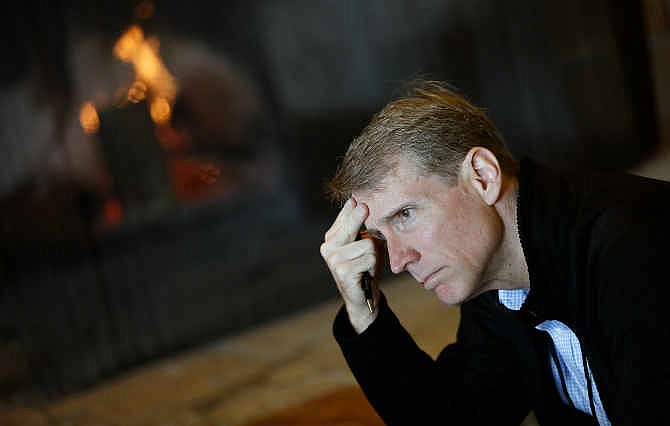 Timothy Adams, president and chief executive officer of the Institute of International Finance, sits by a fire during a break at the Jackson Hole Economic Policy Symposium at the Jackson Lake Lodge in Grand Teton National Park near Jackson, Wyo. Saturday, Aug. 23, 2014.