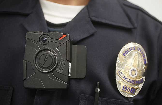 In this Jan. 15, 2014 file photo, a Los Angeles Police officer wears an on-body camera during a demonstration for media in Los Angeles. The fatal police shooting of the unarmed black teenager in Ferguson, Mo. has prompted calls for more officers to wear so-called "body cameras," simple, lapel-mounted gadgets that record the interactions between the public and law enforcement. 