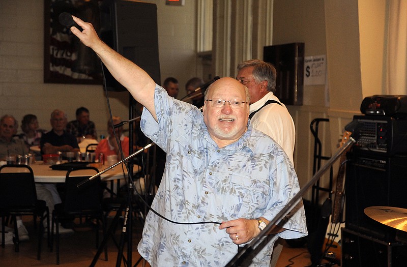 Mike Eveler of Starlight Memories Band turns the mic over to the audience to help sing "Takin' Care of Business" at Sunday's second annual tribute to Rick Stokes, a popular local musician who died suddenly in 2012. 