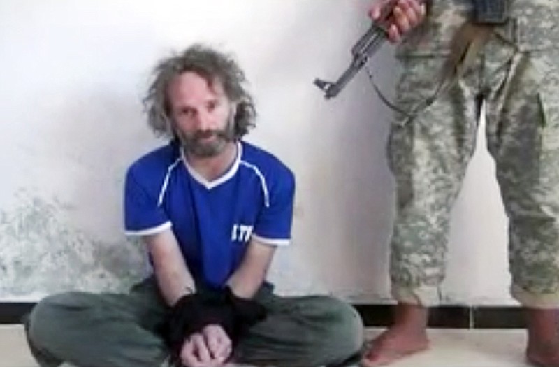 In this image made from undated video obtained by The Associated Press, a man believed to be Peter Theo Curtis, a U.S. citizen held hostage by an al-Qaida linked group in Syria, delivers a statement. The U.S. government said on Sunday that Curtis, who had been held hostage for about two years, had been released.