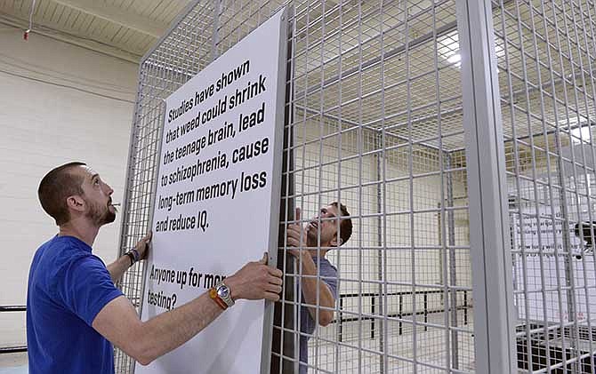 In an Aug. 8, 2014 photo, crew members Andrew Willey, left, and Brian Houchin at Proctor Productions, Inc. in Denver finish assembling large cages, for the "Don't be a Lab Rat" advertising campaign by the state through Sukle Advertising designed to keep kids from using marijuana. The provocative anti-marijuana campaign aimed at Colorado youths has angered marijuana activists for its tag line, "Don't Be a Lab Rat." Now, the Boulder Valley School District is declining to display a human-size cage used in the campaign. Instead, the cage will be displayed near a city park through Sept. 15. (AP Photo/The Denver Post, Kathryn Scott Osler)