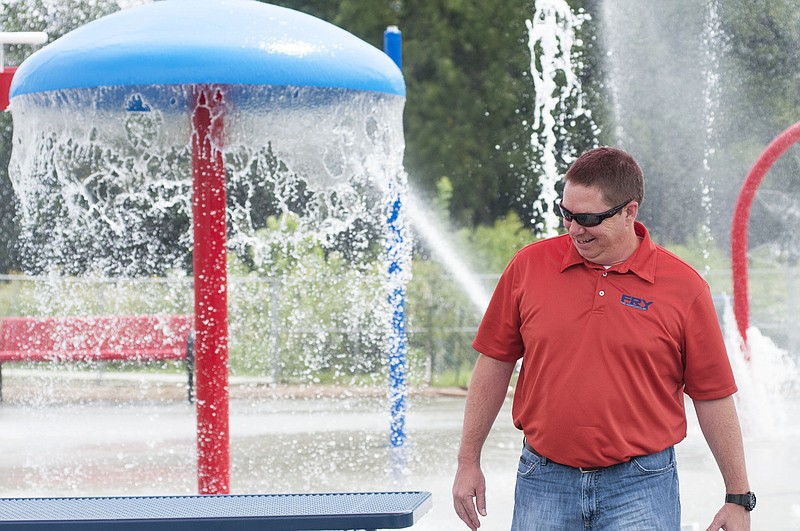 Jack Fry, president of Fry & Associates, smiles as he looks over the new splash pad at Memorial Park on Wednesday. A crew tested the water pressure to ensure the safety for children. Fry said workers are "fine tuning" the splash pad and then they will fill in the surrounding area with grass. Fry & Associates has installed about eight splash pads in Missouri, according to Jack Fry. He said the water feature is growing in popularity as it requires less maintenance and supervision compared to swimming pools. "Kids are going to play in fountains anyway, so you might as well design some fountains they can play in," Fry said.