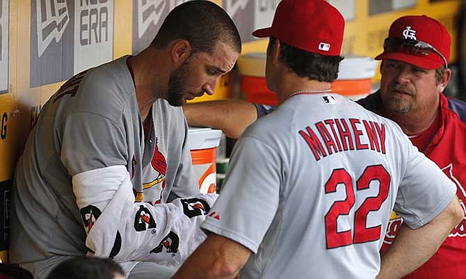 St. Louis Cardinals starting pitcher Adam Wainwright, left, talks with manager Mike Matheny (22) and pitching coach Derek Lilliquist in the dugout during the sixth inning of a baseball game against the Pittsburgh Pirates in Pittsburgh, Wednesday, Aug. 27, 2014. The Pirates won 3-1.