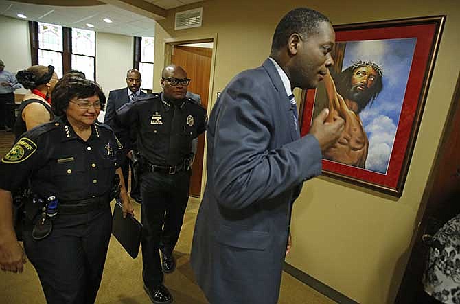 In this photo taken on Aug. 18, 2014, Dallas County District Attorney, Craig Watkins. right, with Dallas Police Chief David Brown, center, and Dallas County Sheriff Lupe Valdez walk into an open meeting at the St. Paul United Methodist Church in Dallas, to address the concerns of police shootings.