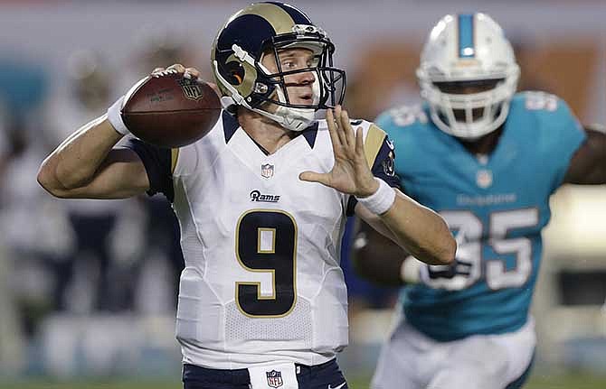 St. Louis Rams quarterback Austin Davis (9) looks to pass as Miami Dolphins defensive end Dion Jordan (95) approaches, during the first half of an NFL preseason football game, Thursday, Aug. 28, 2014, in Miami Gardens, Fla. 