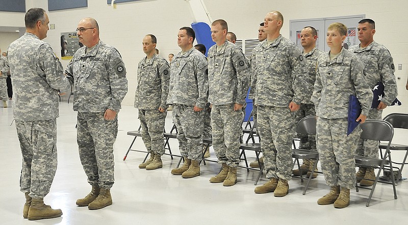 Maj. Gen. Stephen Danner, left, shakes hands with Lt. Col. Michael Kinder, as Danner releases the troops to Kinder's command. Members of the 35th Infantry Division will be shipping out to Camp Bondsteel, Kosovo, after Friday's deployment ceremony at the Ike Skelton Training Site. The 12-soldier element will serve on a peacekeeping mission in the Balkans.