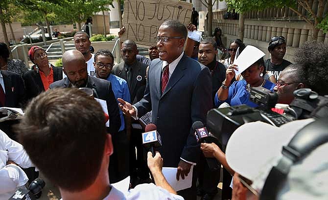 Malik Z. Shabazz, president and founder of Black Lawyers for Justice based in Washington, D.C., holds a news conference in front of the federal courthouse in St. Louis on Thursday, Aug. 28, 2014 where he announced the details of a $40 million lawsuit his organization filed against police and the governments of Ferguson and St. Louis County. The lawsuit alleges that police in Ferguson and St. Louis County used excessive force and falsely arrested innocent bystanders amid attempts to quell widespread unrest after the fatal shooting of a black 18-year-old by a white police officer.