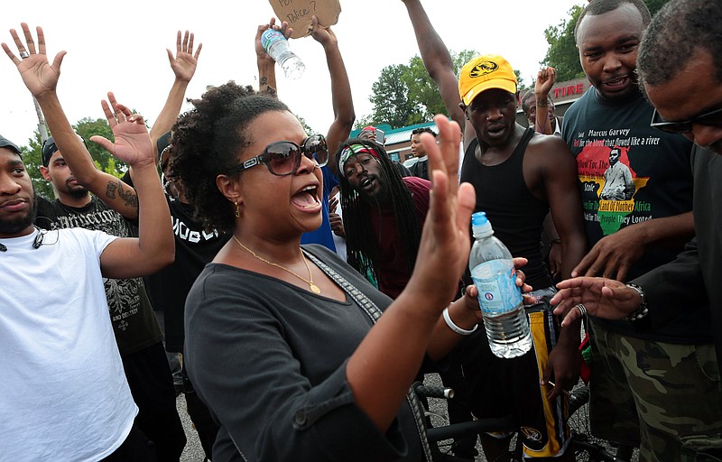 In this Aug. 10, 2014 photo, Missouri State Sen. Maria Chappelle-Nadal talks with protesters who blocked South Florissant Road in front of the Ferguson, Mo., police station. 