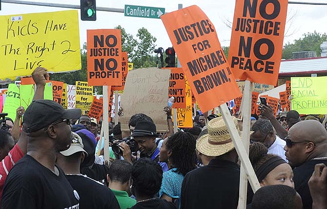 Demonstrators gather for a rally in Ferguson, Mo. on Saturday, Aug. 30, 2014 near the site where Michael Brown, an unarmed black 18-year-old, was fatally shot by a white police officer three weeks earlier.