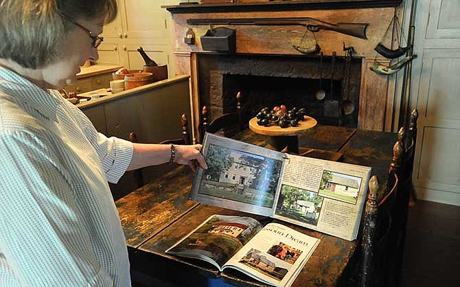 Carolyn Green looks through publications which published features on Rock Enon, including Better Homes and Gardens' Country Home magazine in 1988 and in The Settlement Book by Simple Life Magazine in 2011.
