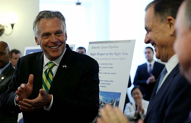 Virginia Gov. Terry McAuliffe,left, leads applause during an announcement at the State Capitol in Richmond, Va., Tuesday, Sept. 2, 2014, of a major gas pipeline through parts of Virginia, West Virginia and North Carolina. He was accompanied by Virginia Natural Gas Chairman Hank Linginfelter, partially hidden, right, and Dominion Resources CEO Tom Farrell, second from right.