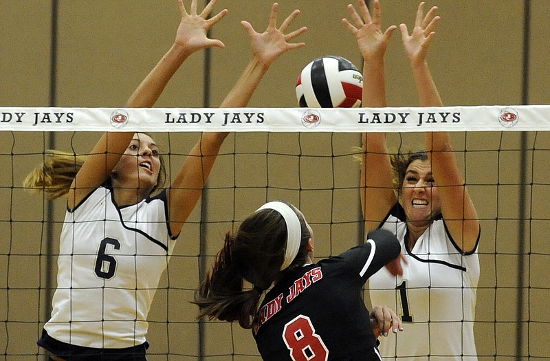 Helias teammates Molly Sandbothe (6) and Tory Wiley (1) go up at the net in an attempt to block a shot by Jefferson City middle hitter Madisyn Stone during Tuesday's match at Fleming Fieldhouse.