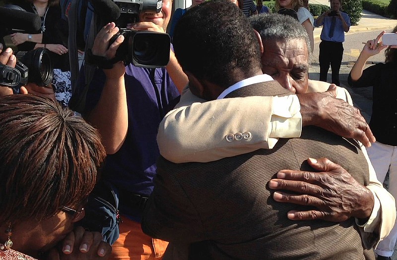 James McCollum, facing camera, embraces his son Henry following the younger man's release from Central Prison in Raleigh, N.C., on Wednesda. Henry McCollum spent more than 30 years on death row for a rape and murder he didn't commit. McCollum's stepmother Priscilla McCollum is at left.
