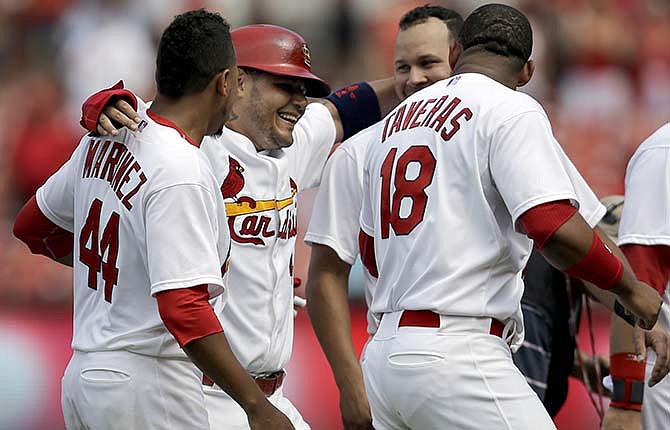 St. Louis Cardinals' Yadier Molina, second from left, celebrates with teammates Carlos Martinez (44), Oscar Taveras (18) and Jhonny Peralta after scoring a baseball game-winning run on a single by Peter Bourjos during the ninth inning against the Pittsburgh Pirates, Wednesday, Sept. 3, 2014, in St. Louis. The Cardinals won 1-0. 