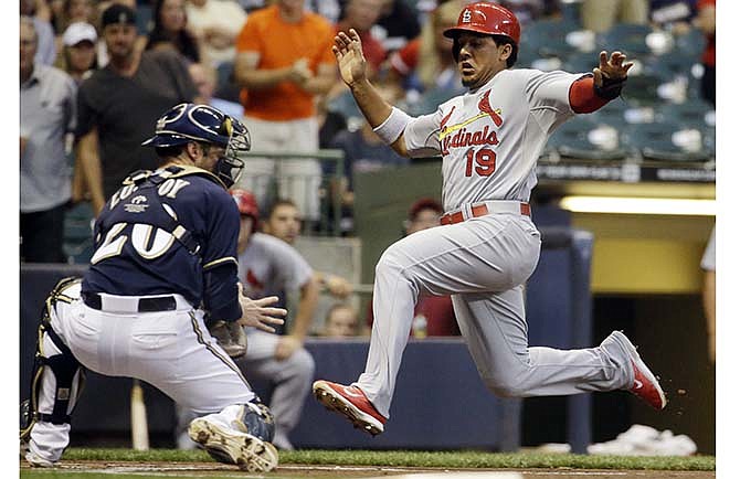 St. Louis Cardinals' Jon Jay scores past Milwaukee Brewers catcher Jonathan Lucroy during the first inning of a baseball game Thursday, Sept. 4, 2014, in Milwaukee. Jay scored from second on a hit by Yadier Molina.