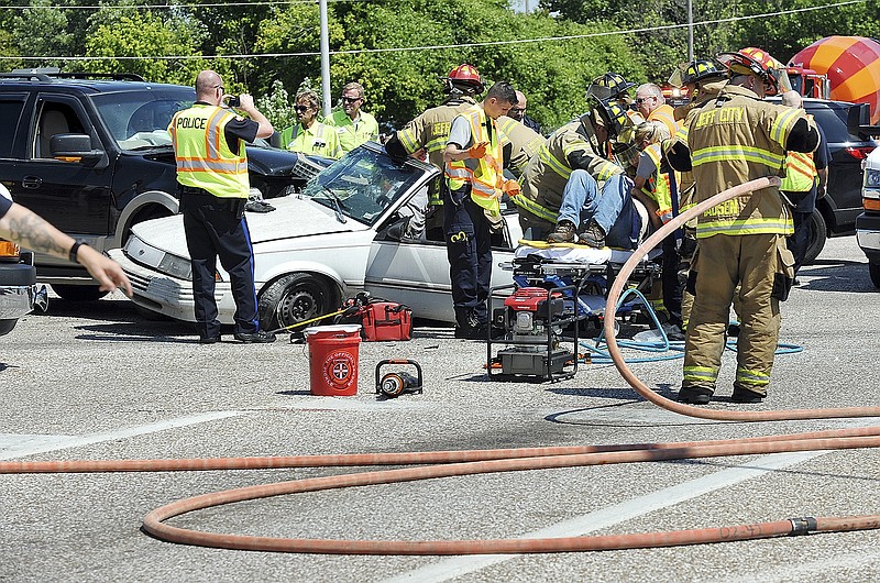 The driver of the Chevy Cavalier is extricated from the vehicle after colliding with the Ford Expedition at the intersection of U.S. 50/63 and Missouri Boulevard Friday afternoon.