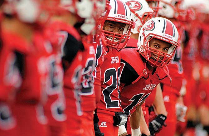 Jefferson City defensive backs Edmund Coley (20) and Dennis Barnes (11) share a laugh as they and their fellow Jays line up for the coin toss prior to the start of last Friday night's matchup against C.B.C. at Adkins Stadium.