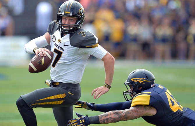 Missouri quarterback Maty Mauk (7) scrambles from Toledo linebacker Trent Voss (43) in the first quarter of an NCAA college football game in Toledo, Ohio, Saturday, Sept. 6, 2014.