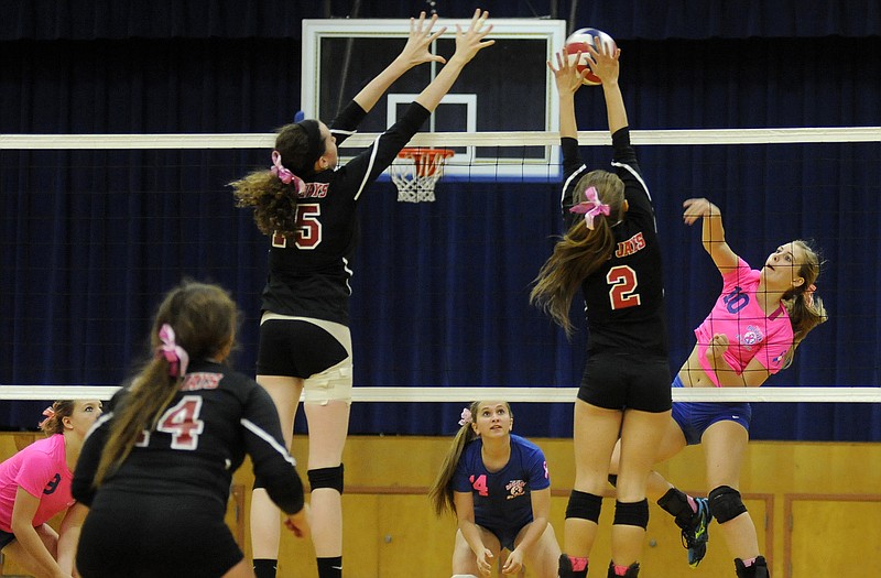 Fatima outside hitter Haley Luebbering goes up for a shot as Jefferson City teammates Mary Wehmeyer (15) and Chelsey Klosterman (2) defend during Monday night's match in Westphalia.