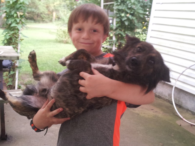 Bronc Hibdon with his dog, Opossum, who is missing. He is a short legged black and brown brindle. Please call the Hibdons if you see him.