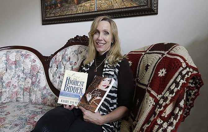 Author Rachel Ann Nunes poses with two versions of her Christian romance novel at her home Tuesday, Sept. 9, 2014, in Orem, Utah. Nunes says a schoolteacher plagiarized her Christian romance novel, added graphic sex scenes and passed it off as her own. In a case she says brings to light plagiarism in the burgeoning world of online self-publishing, Nunes filed a federal lawsuit in August against a Layton, Utah, teacher. Nunes is seeking at least $150,000 in damages as well as attorney's fees in the suit, which was first reported by the Ogden Standard-Examiner.