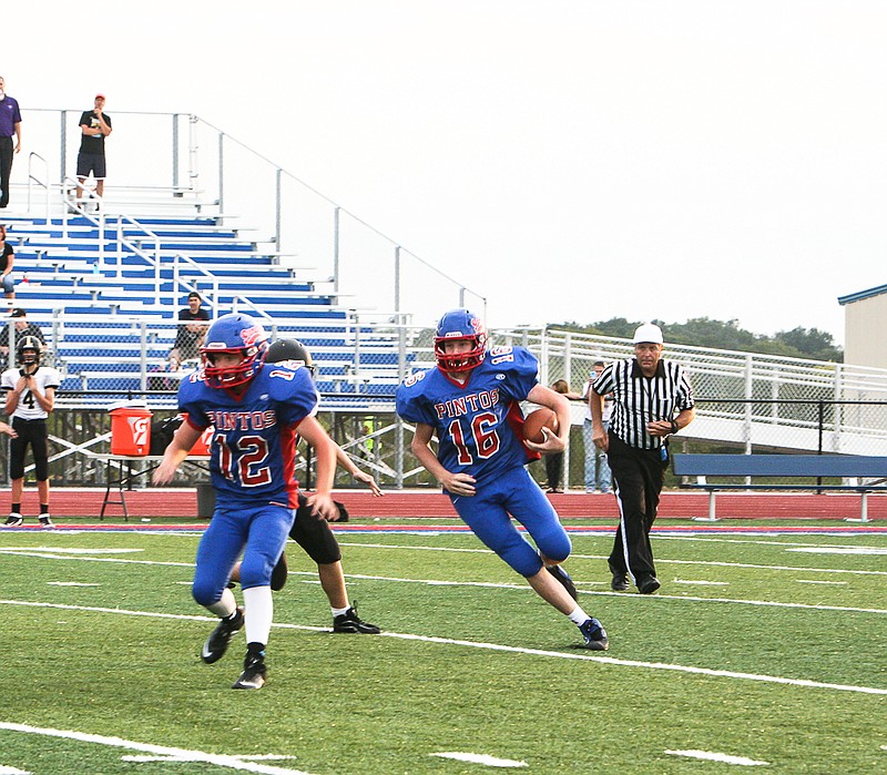 California's JV quarterback Jacob Wolken (16) gains yardage on a keeper in the fourth quarter of the home game against Versailles Monday at Riley Field. The JV Pintos defeated the Tigers 49-7.
