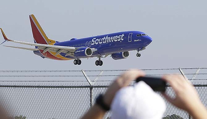 A Southwest Airlines plane flies over Love Field Monday, Sept. 8, 2014, in Dallas.