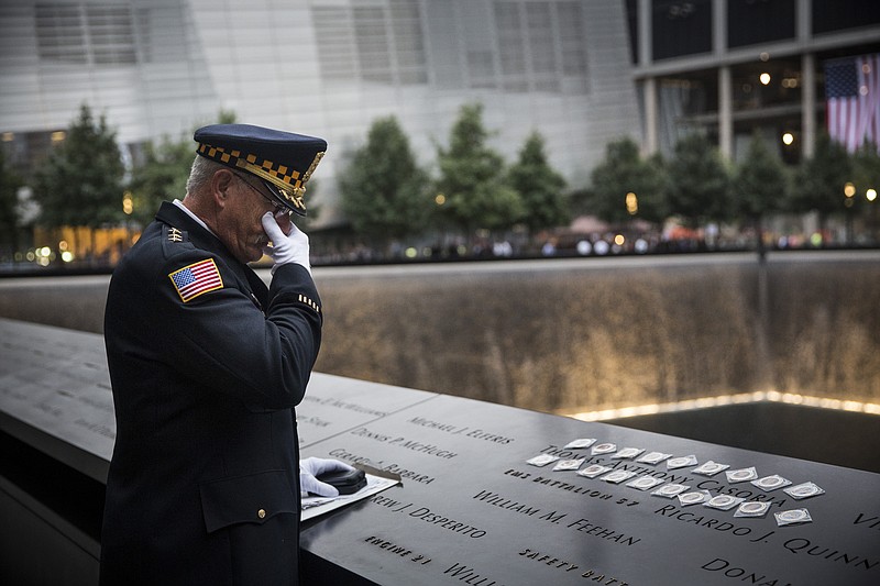 Sam Pulia, mayor of Westchester, Ill., and a former police officer of the same town, mourns over the name of his cousin, New York firefighter Thomas Anthony Casoria, who was killed in the South Tower in the attacks of Sept. 11, 2001, prior to the the memorial observances held at the site of the World Trade Center in New York, Thursday, Sept. 11, 2014. This year marks the 13th anniversary of the terrorist attacks that killed nearly 3,000 people at the World Trade Center, Pentagon and on Flight 93 over Pennsylvania. 