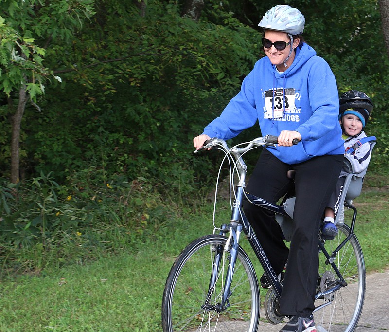 Nicole Waters bikes with her 3-year-old son, Cole, in Memorial Park on Saturday as part of the Faith Maternity Care 5K. Waters and her two sons biked the trail a lot this past summer. When Waters told her son they were going to walk in the 5K, he asked if they could bike instead.