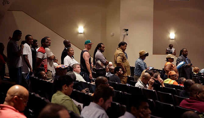In this Sept. 9, 2014 file photo, a line of people wait to speak during a meeting of the Ferguson City Council Tuesday, in Ferguson, Mo. The meeting was the first for the city council after the fatal shooting of Michael Brown by a city police officer. Political participation is increasing on the national level for blacks and Hispanics. On the local level, voting continues to be struggle, as it is in this St. Louis suburb.