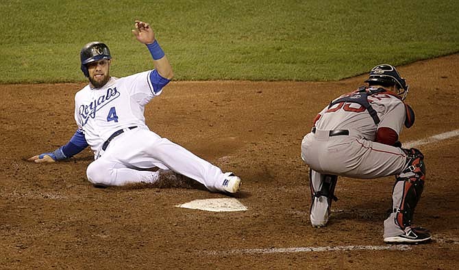 Kansas City Royals' Alex Gordon (4) beats the tag at home by Boston Red Sox catcher Christian Vazquez to score on a single by Omar Infante during the eighth inning of a baseball game Saturday, Sept. 13, 2014, in Kansas City, Mo.