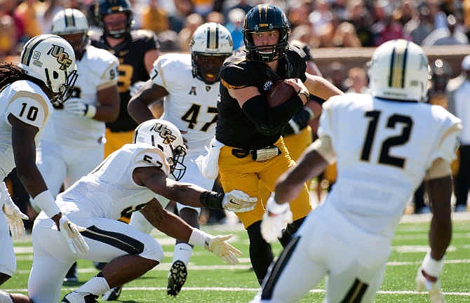 Missouri quarterback Maty Mauk, center, scrambles for yardage between Central Florida's Jacoby Glenn (12), Shaquill Griffin (10), Deion Green (47) and Troy Gray (57) during the second quarter of an NCAA college football game Saturday, Sept. 13, 2014, in Columbia, Mo. 
