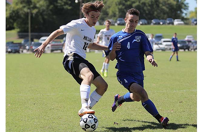 Braden Remmert of Helias makes a direction change against the defense of Squire Holt of Washington during Saturday's action at the 179 Soccer Park in Jefferson City.